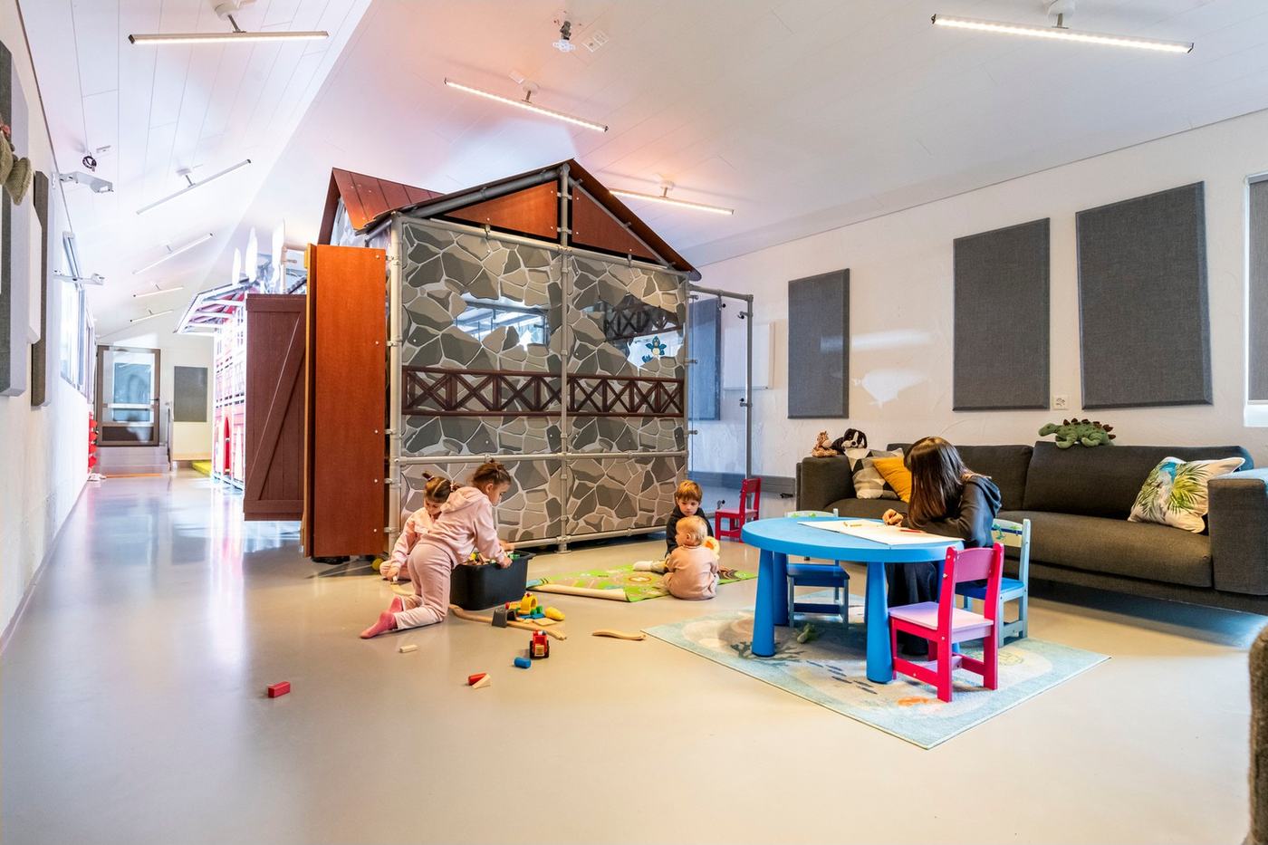 Kinder spielen, Eltern sitzen in der Lounge daneben